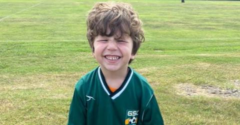 Noah Ennis smiles wearing a soccer uniform