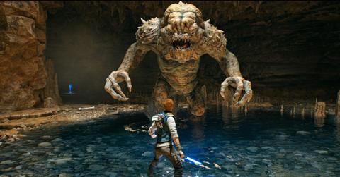 Star Wars Jedi: Survivor Cal facing off against the Rancor in a cave.