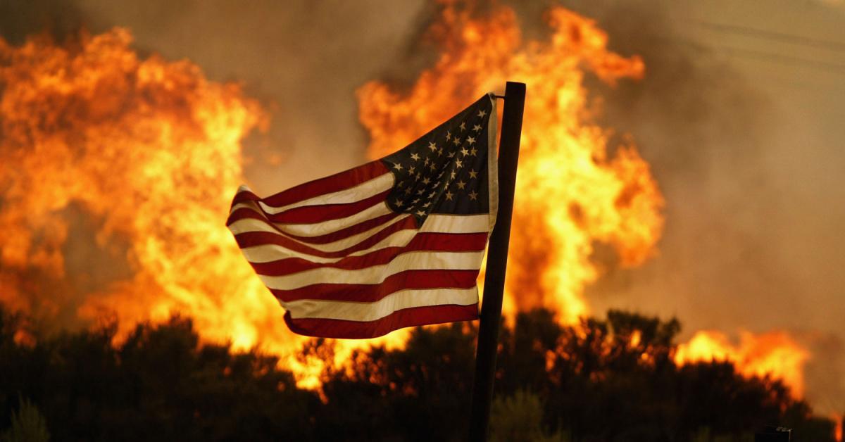Flames approach an American flag at the Crown Fire on July 20, 2004 near Acton, California.