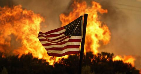 Flames approach an American flag at the Crown Fire on July 20, 2004 near Acton, California.