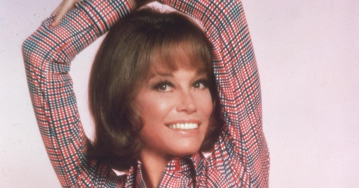 circa 1975: Studio portrait of American actor Mary Tyler Moore, wearing a red, white and blue striped shirt tied at the waist and smiling with her arms over her head. (Photo by Hulton Archive/Getty Images)