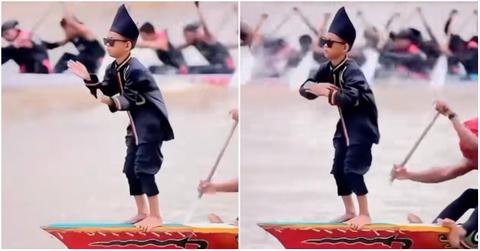 An Indonesian kid on a rowing boat dancing.