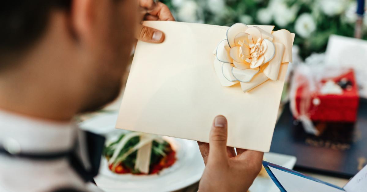 A groom holding a card after his wedding ceremony.