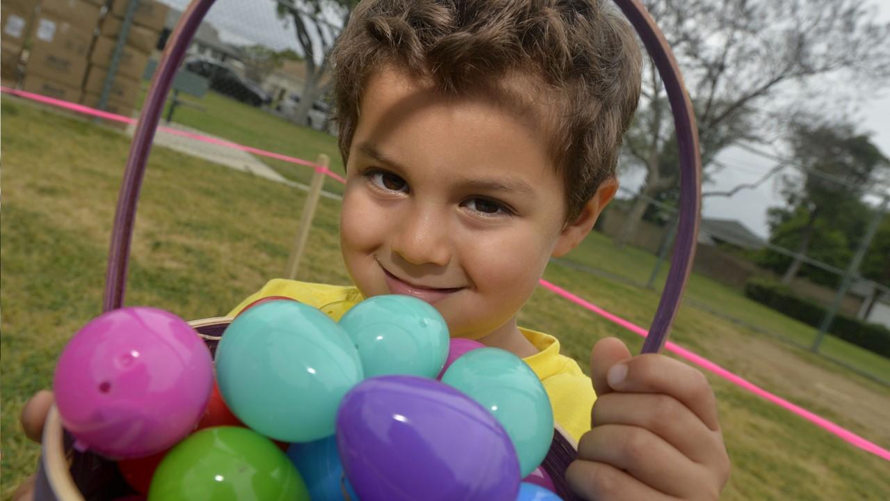 A young boy holding a basket with Easter eggs