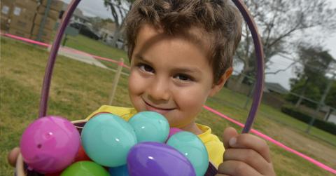 A young boy holding a basket with Easter eggs