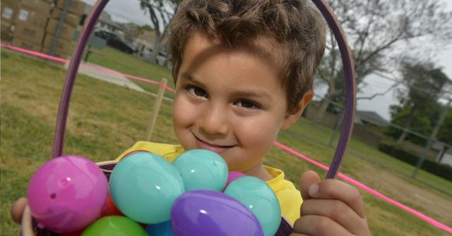A young boy holding a basket with Easter eggs