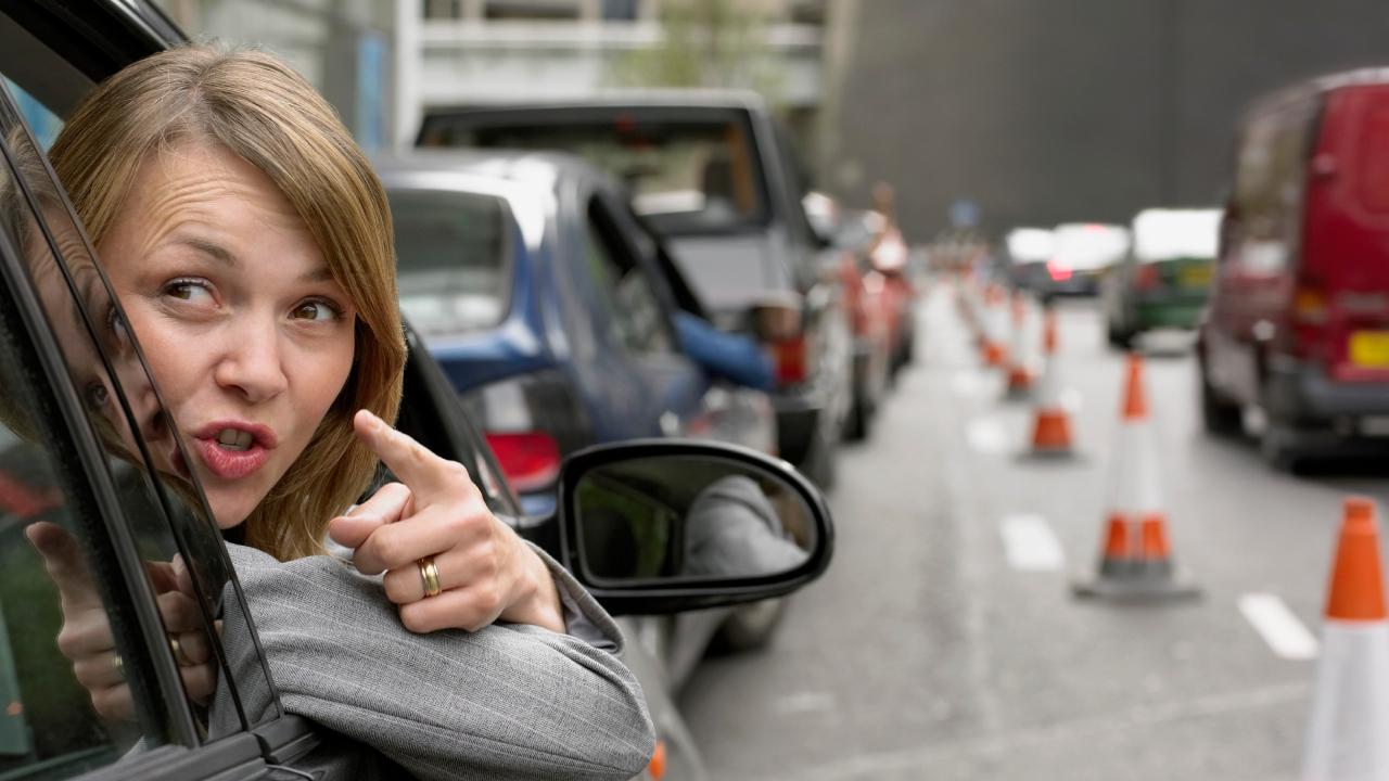 woman angrily points out a car window