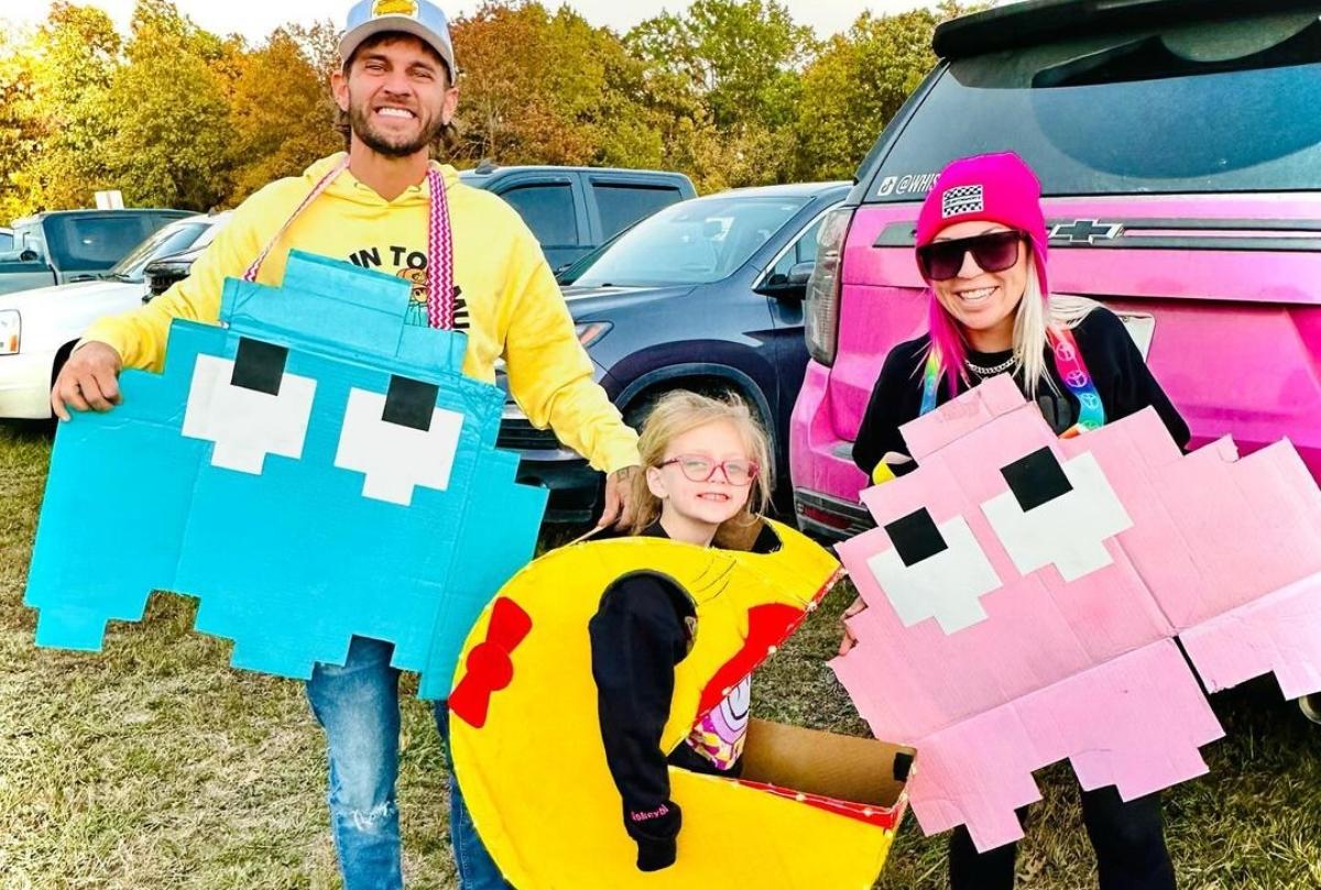 Bryce Sparks with his wife and daughter dressed for Halloween in a parking lot