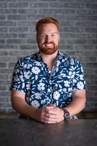 Michael is dressed in a blue and white Hawaiian shirt, smiling for his official portrait for Season 2 of 'The Mole.'