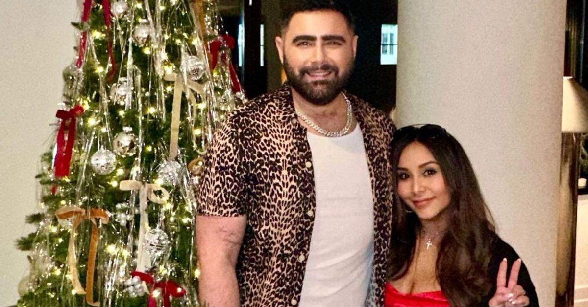 Joey Camasta and Snooki pose for a photo in front of a Christmas tree