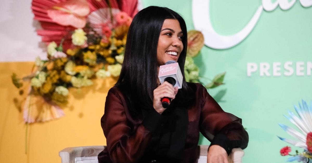 Kourtney Kardashian in a dark red silk top.