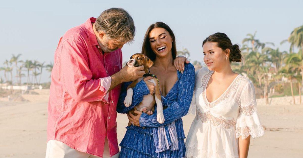 Todd (left) pets the puppy that Bronwyn (center) is holding while her daughter Gwen (right) looks on.