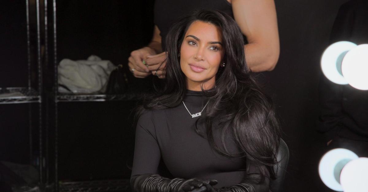 Kim Kardashian sits at a table in her dressing room