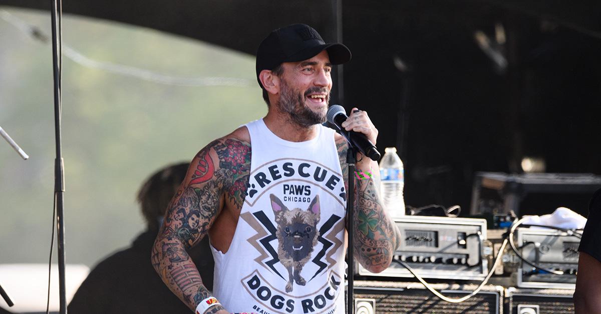 CM Punk speaking into a mic at Riot Fest 2021. 