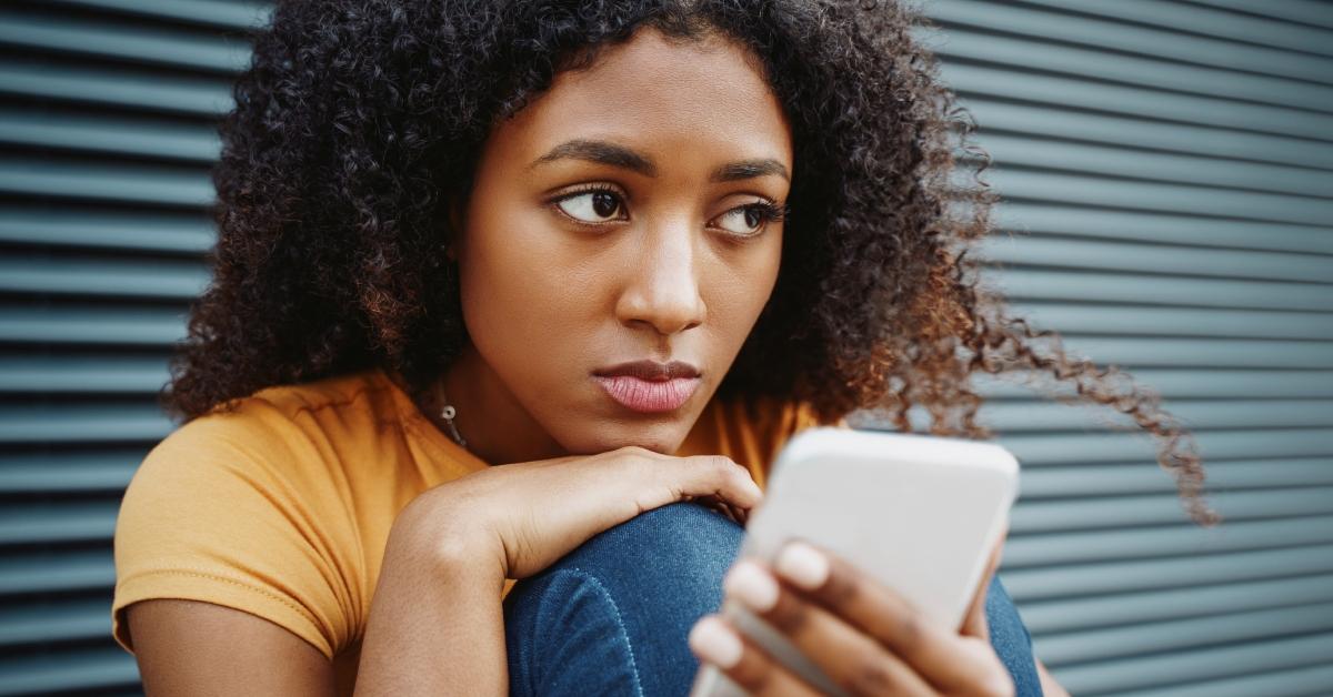 woman disappointed with phone in hand