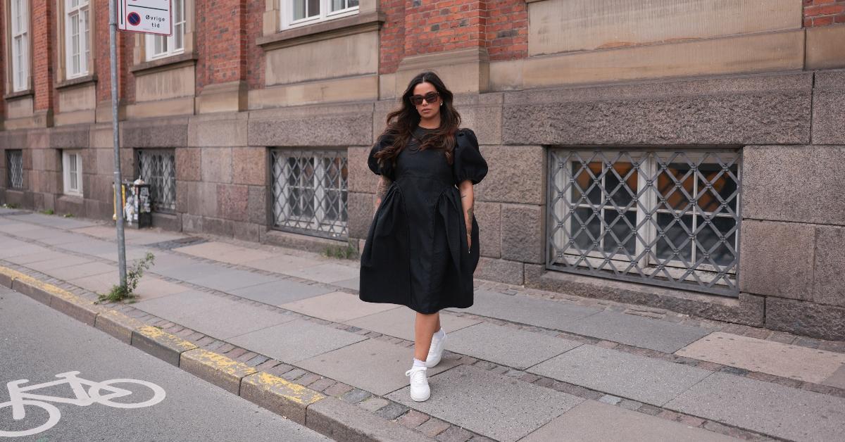 Model Naomi Anwer pairing a little black dress with white sneakers.