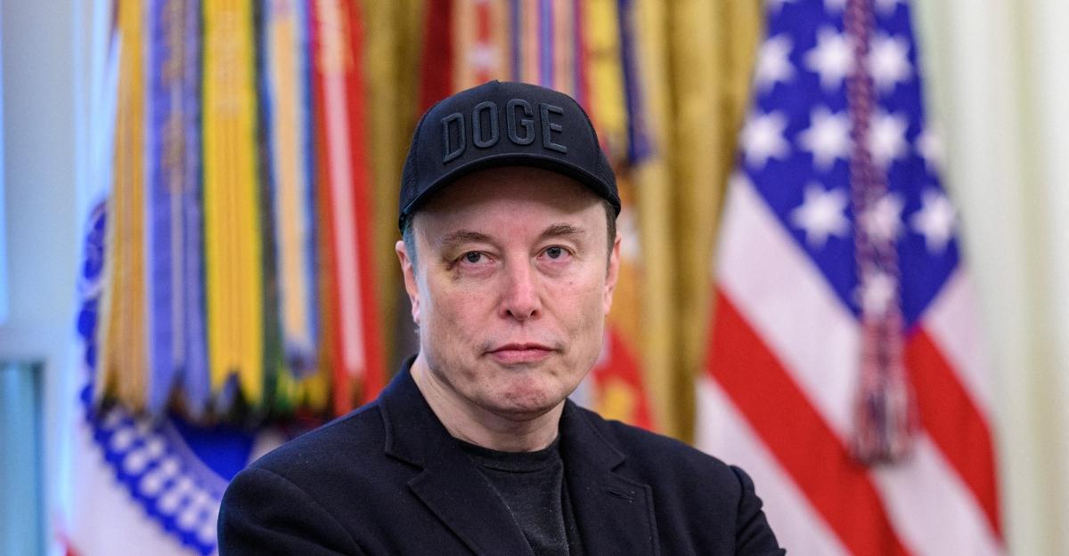 Elon Musk wears a DOGE hat during a press conference at the White House