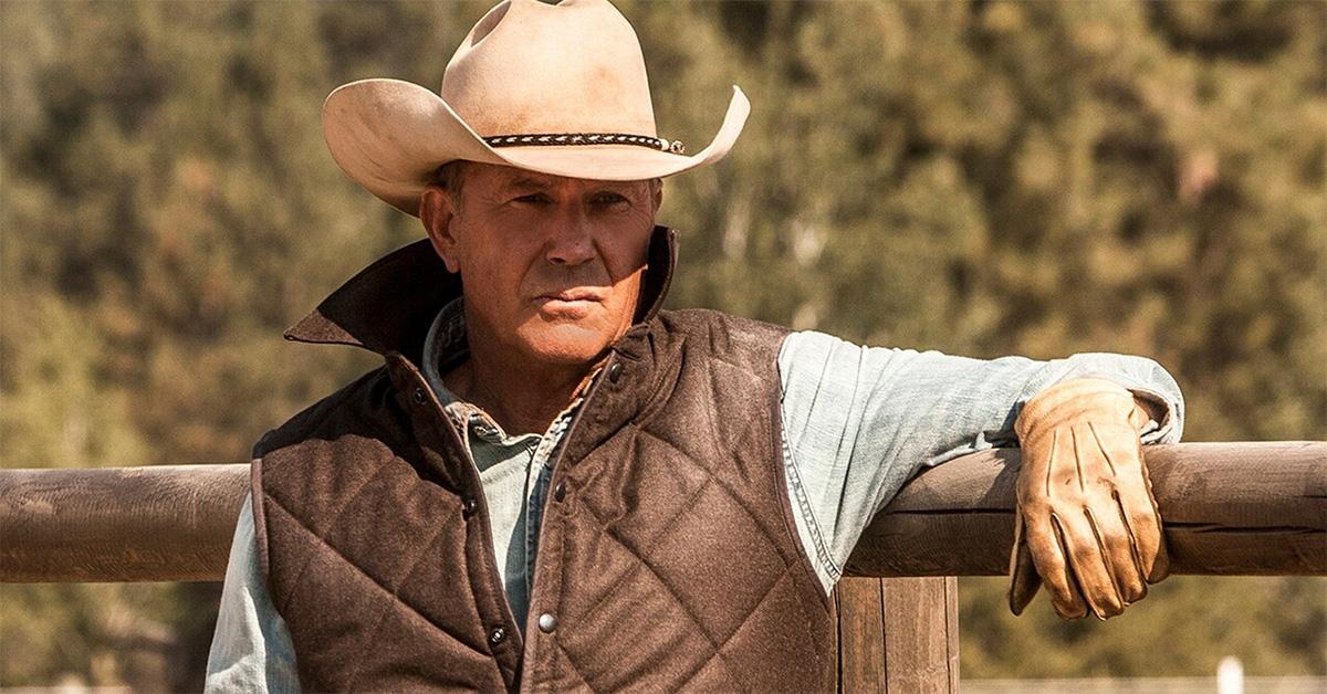 Kevin Costner leaning on a fence in 'Yellowstone.' 