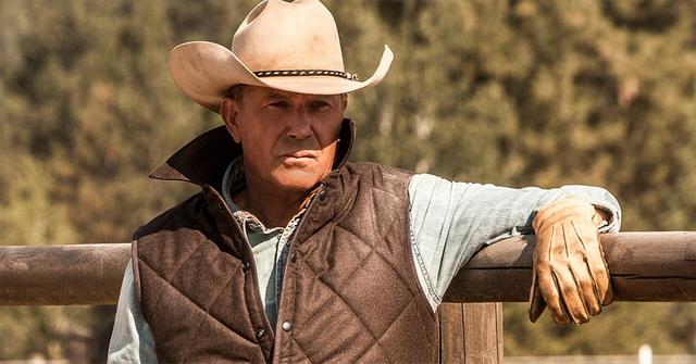 Kevin Costner leaning on a fence in 'Yellowstone.'