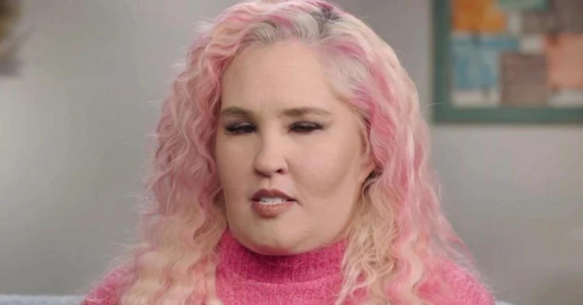 Mama June with pink hair and pink sweater talks in a confessional 