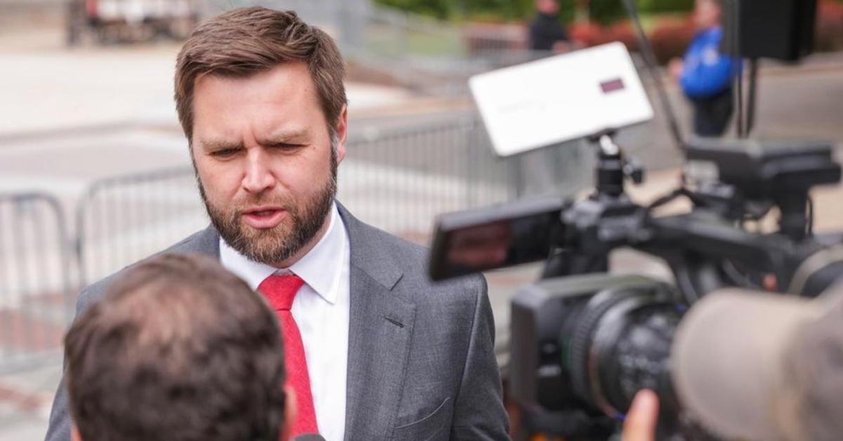 JD Vance wears a red tie, talks to reporters outside