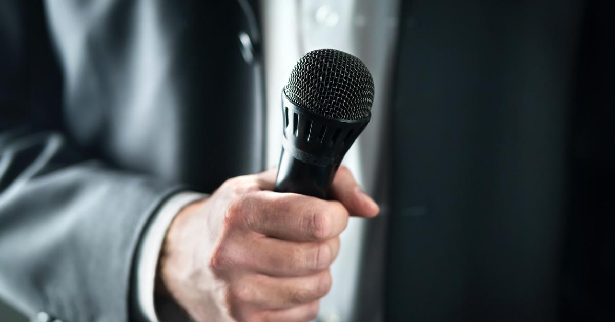 business man holding microphone public speaking and giving speech in picture id