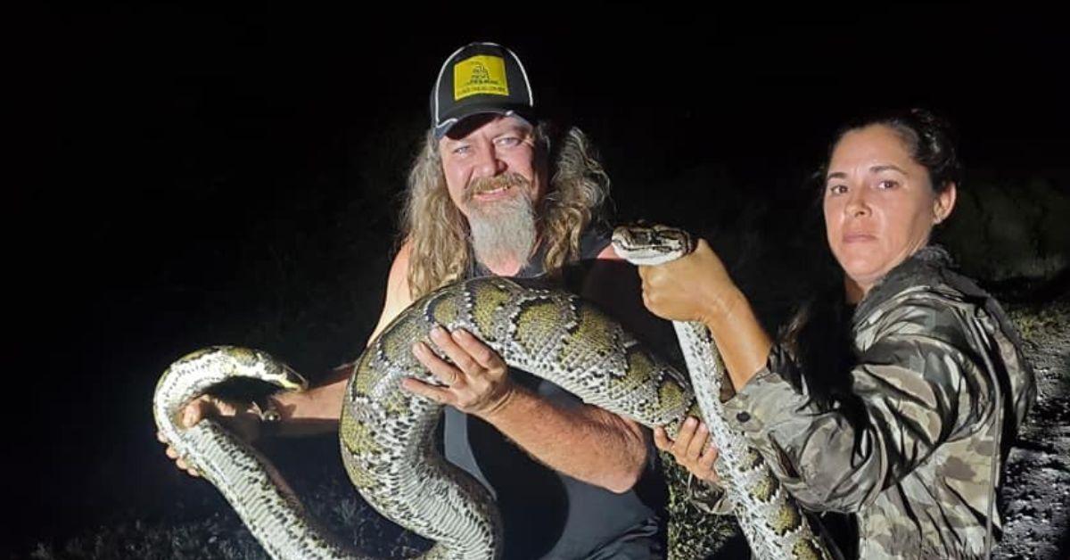 Natalee Mckinney and Dusty Crum hold a python together