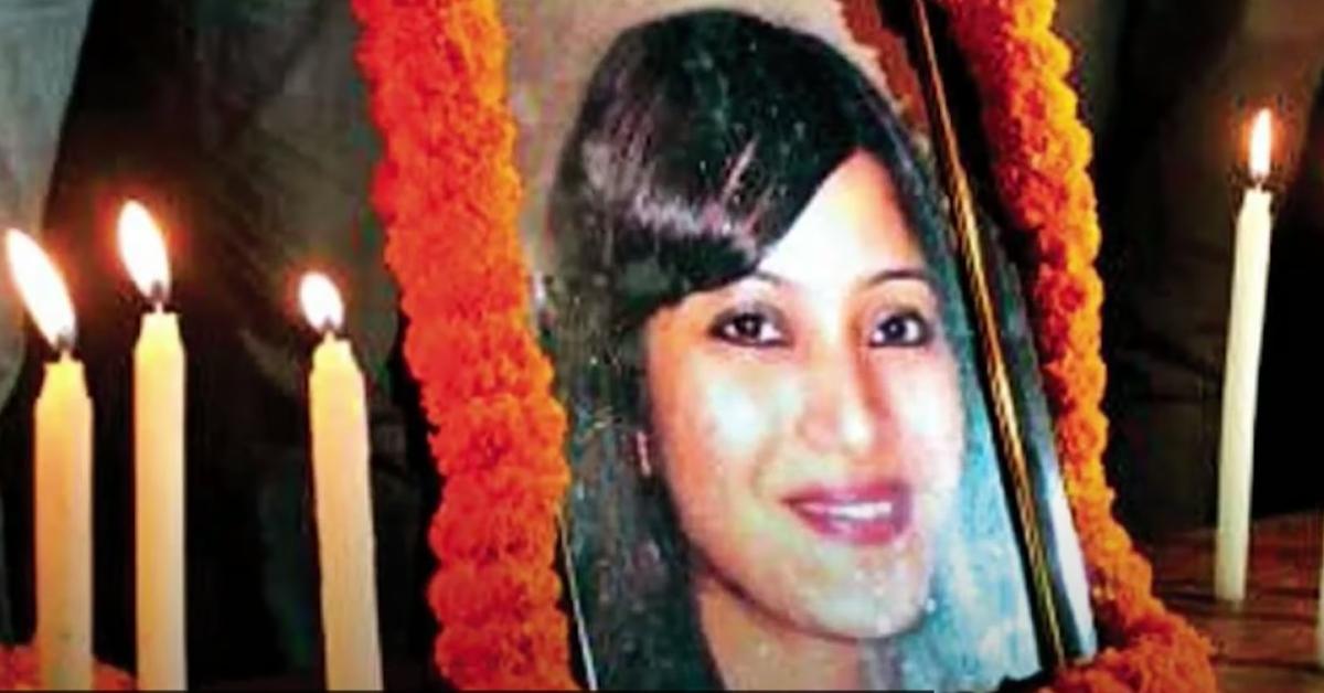 A framed picture of Sheena Bora sits on a table surrounded by candles, as part of a vigil.