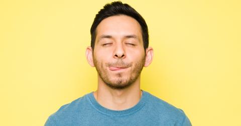 man with eyes closed and tongue out.