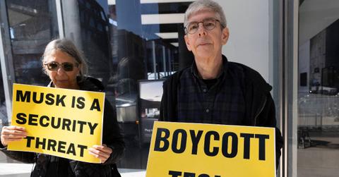 Protesters outside of a Tesla dealership.