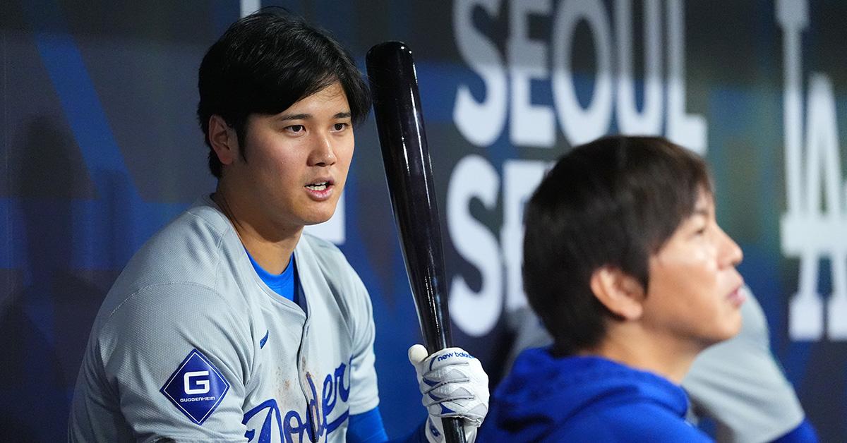 Shohei Ohtani #17 of the Los Angeles Dodgers talks to his interpreter Ippei Mizuhara in the dugout during the 2024 Seoul Series game between Los Angeles Dodgers and San Diego Padres at Gocheok Sky Dome on March 20, 2024 in Seoul, South Korea. (Photo by Masterpress/Getty Images)