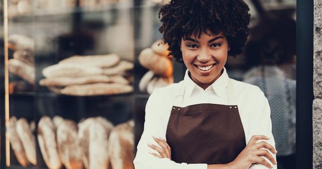 A Black female standing outside of her store