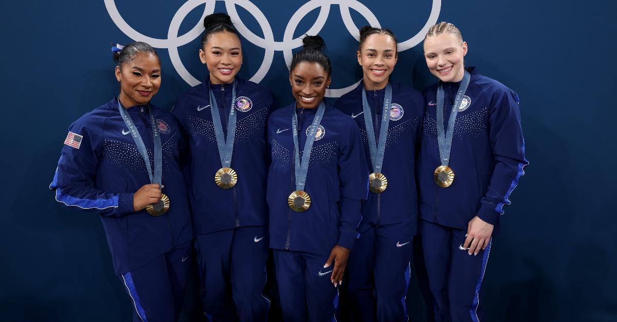 Jordan Chiles, Suni Lee, Simone Biles, Hezly Rivera, and Jade Carey wearing their gold medals at the Paris Olympics in 2024