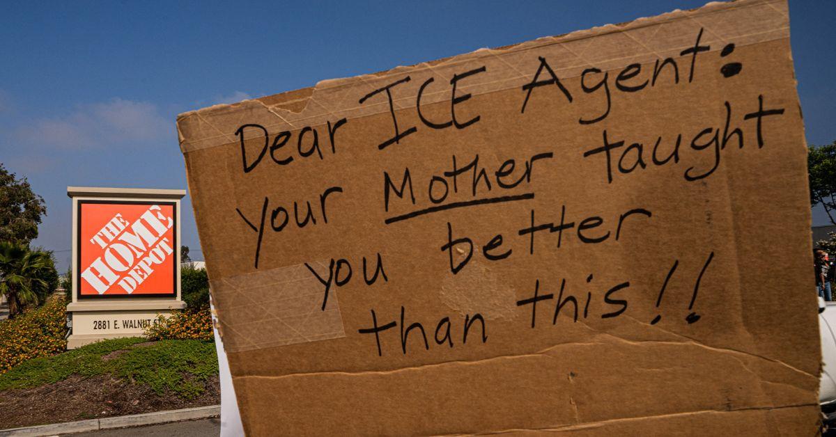 Protesters holding signs outside of a Home Depot.