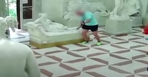 tourist breaks statue sitting cover