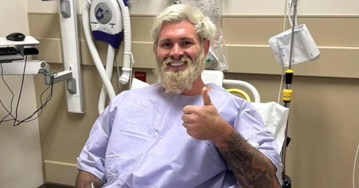 Gordon Ryan gives a thumbs up while wearing a purple hospital gown.