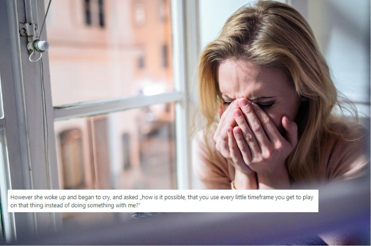 Image of woman crying next to a window.