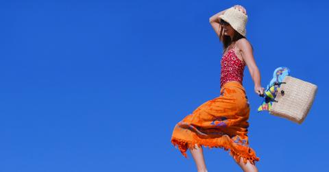 A woman skipping on the beach.