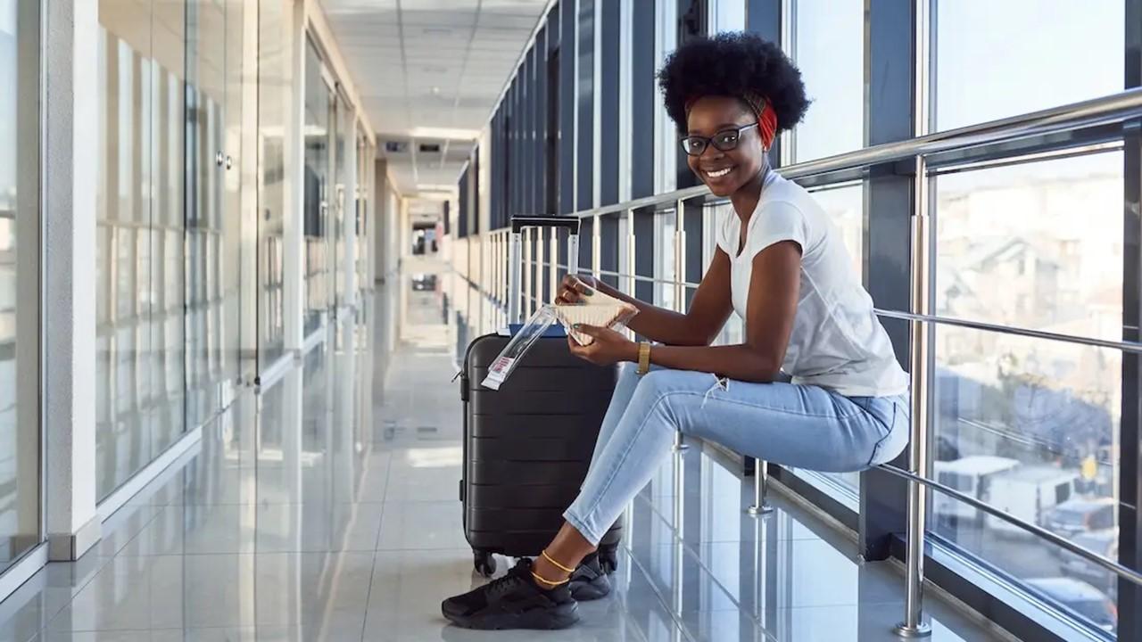 A woman sitting down with her luggage in an airport