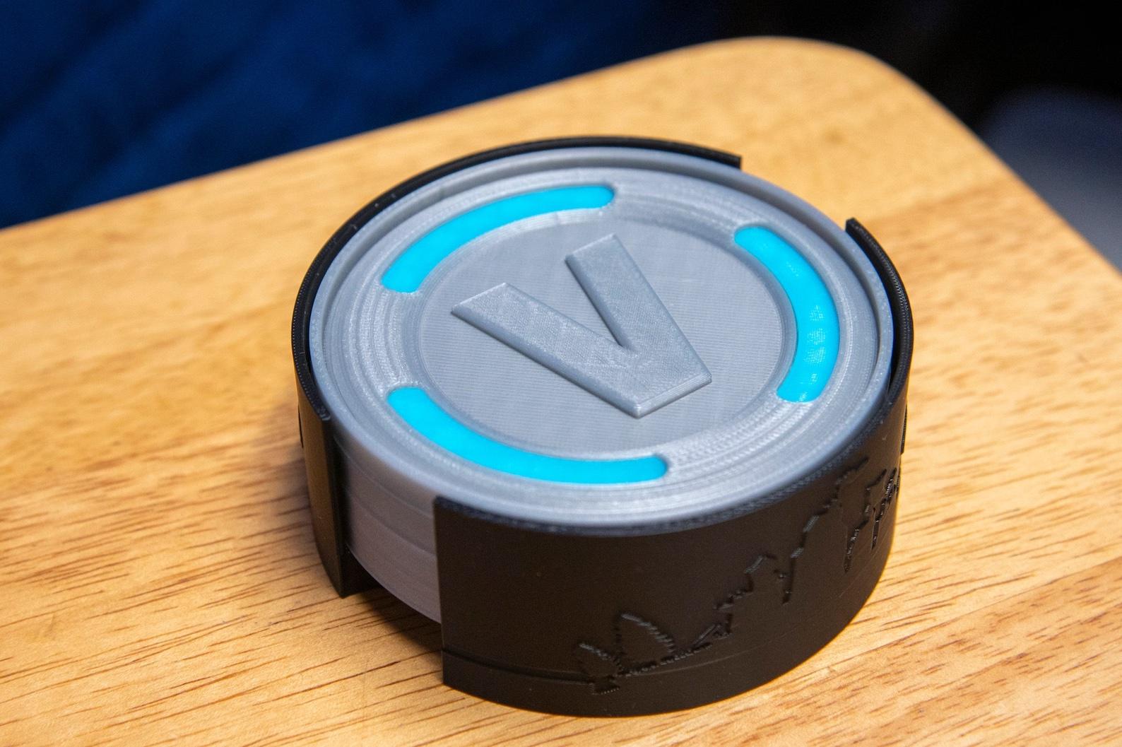 coasters shaped like vbucks in a black holder