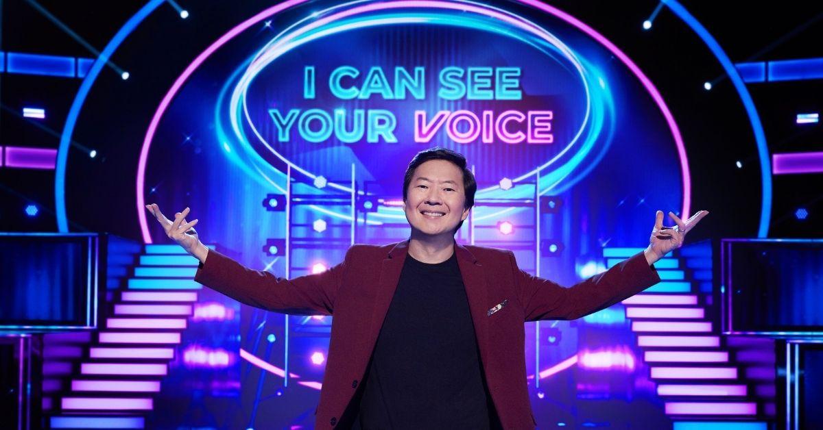 Ken Jeong hosting 'I Can See Your Voice' in a maroon jacket and black shirt.