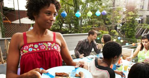 Woman holds plate of food at cookout