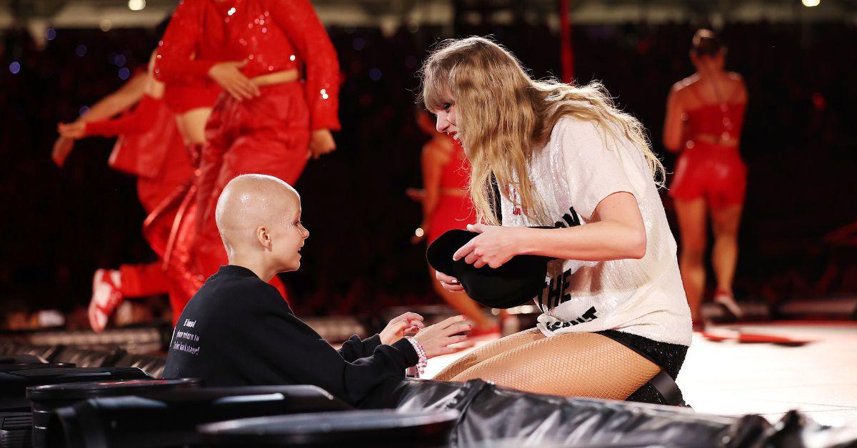 Taylor Swift handing the '22' hat to a fan