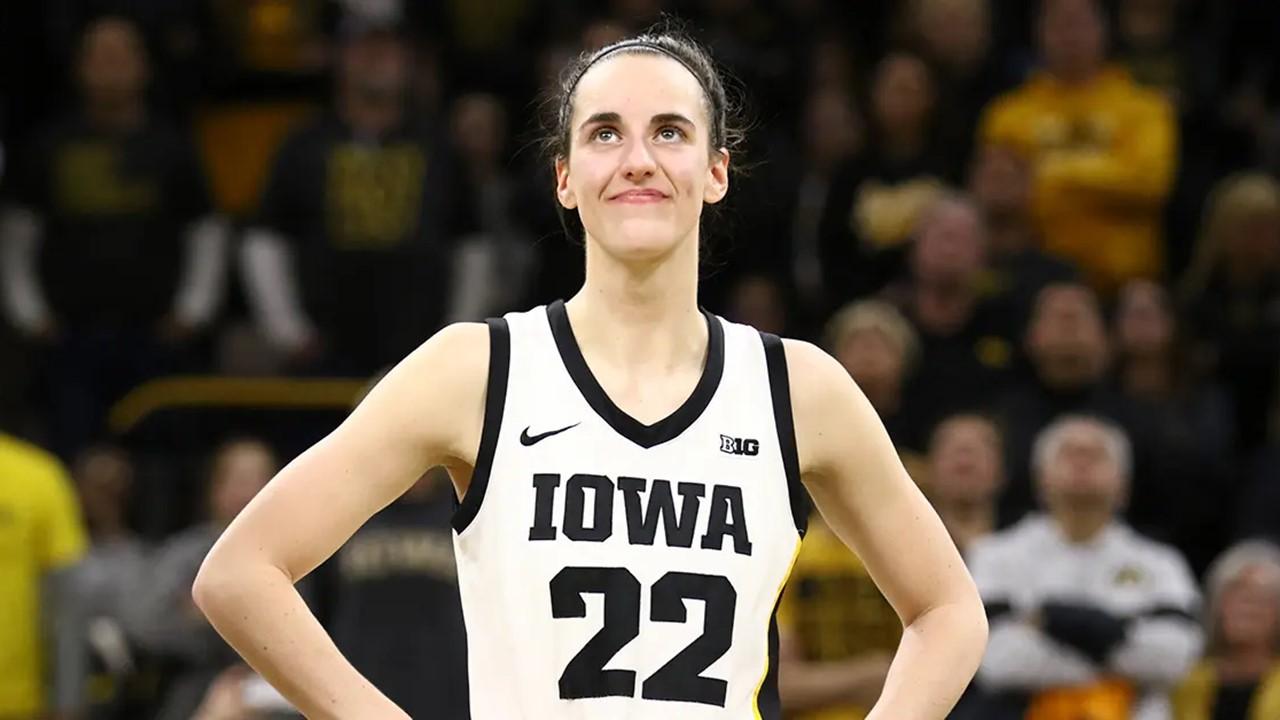 Caitlin Clark smiling as the crowd cheers after she broke the NCAA women's all-time scoring record on Feb. 15, 2024