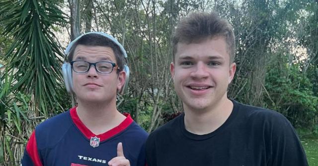 Sketch wears headphones while standing next to a friend