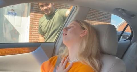 A woman sits in a car after having her wisdom teeth removed
