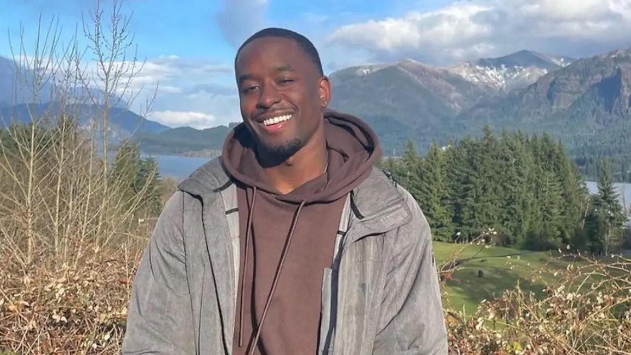 Xavier Bonner standing in the mountains with a lake behind him