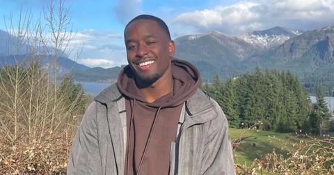 Xavier Bonner standing in the mountains with a lake behind him