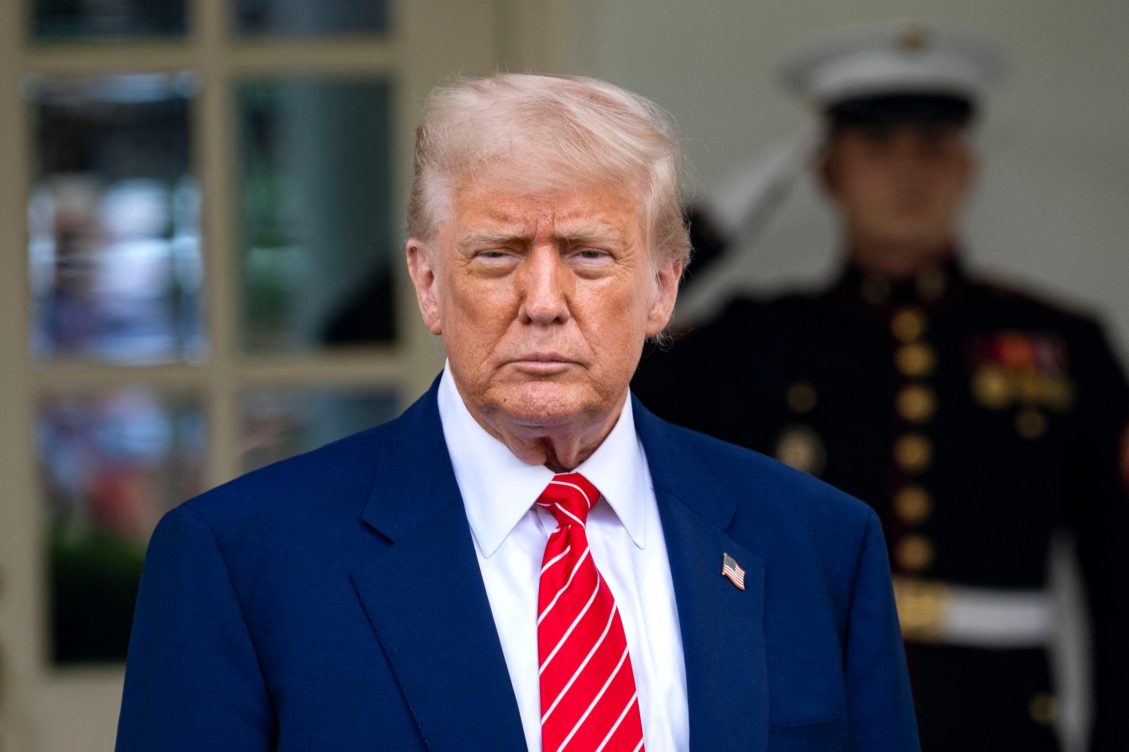 Donald Trump wearing a blue suit and red tie.