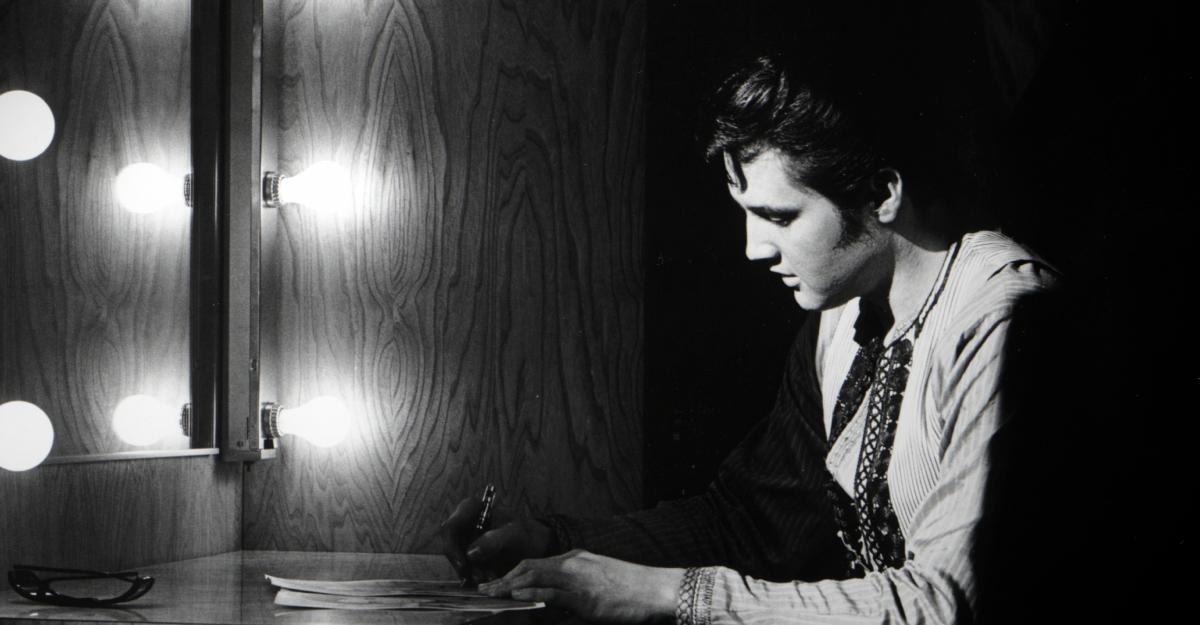 Elvis in a dressing room in front of a mirror, writing, as depicted in Netflix's Return of the King: The Fall and Rise of Elvis Presley.